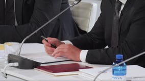 President Zelensky close up hands holding pen and fingers stretches. President of Ukraine Volodymyr Zelensky on