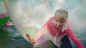 Pret op het Water Een vrolijke meisjespelen binnen een transparante bal in de pool stock footage Pret op het Water Een vrolijke meisjespelen binnen een transparante bal in de pool stock footage