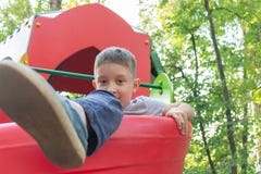 Preteen chłopiec bawić się na dziecka ` s boisku obraz stock Preteen chłopiec bawić się na dziecka ` s boisku obraz stock