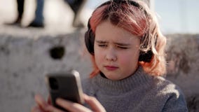 Young boy and girl play games and listen to music on their mobile phones  7468482 Stock Photo at Vecteezy