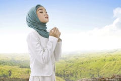 Pretty asian muslim woman wearing hijab raising hand and praying stock photos Pretty asian muslim woman wearing hijab raising hand and praying stock photos