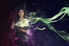 Pretty asian witch woman reading the incantation in book royalty free stock photography Pretty asian witch woman reading the incantation in book royalty free stock photography