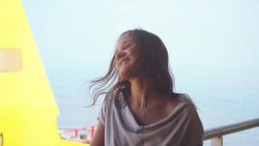 Pretty dreamy young woman wearing headphones listening to music on the sailing ship in slow motion while traveling stock footage Pretty dreamy young woman wearing headphones listening to music on the sailing ship in slow motion while traveling stock footage
