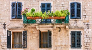 Pretty European house facade, with window shutters, balcony, and potted plants. stock photos Pretty European house facade, with window shutters, balcony, and potted plants. stock photos