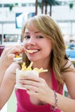 Pretty Girl Eating French-fries Royalty Free Stock Photos
