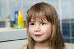 Pretty girl face portrait, smiling child with beautiful eyes and long wet fair hair on blurred background of bathroom stock photography Pretty girl face portrait, smiling child with beautiful eyes and long wet fair hair on blurred background of bathroom stock photography