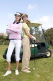 Pretty Golf Players With Their Golf Cars Royalty Free Stock Images
