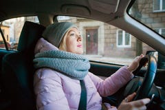 Pretty woman driving car on a cold autumn or winter day stock photography Pretty woman driving car on a cold autumn or winter day stock photography