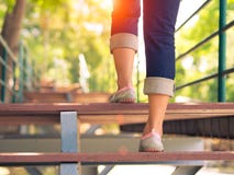 Pretty woman is stepping up a staircase with Lens Flare or sunspot stock photo Pretty woman is stepping up a staircase with Lens Flare or sunspot stock photo