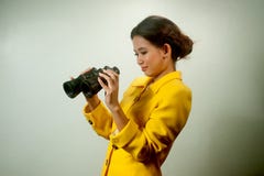 Pretty young Asian businesswoman in yellow suit holding a binoculars. Stock Photography Pretty young Asian businesswoman in yellow suit holding a binoculars. Stock Photography