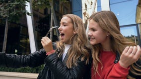 Pretty young girls making funny faces and smiling for selfie photo on smartphone. Outdoors. Friendship, lifestyle stock video footage Pretty young girls making funny faces and smiling for selfie photo on smartphone. Outdoors. Friendship, lifestyle stock video footage