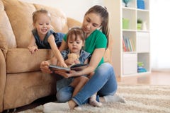 Pretty young mother reading a book to her daughters stock photography Pretty young mother reading a book to her daughters stock photography