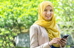 Pretty young muslim woman having a conversation on the phone.