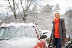 Pretty, young woman cleaning her car from snow stock photo Pretty, young woman cleaning her car from snow stock photo
