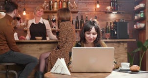 Pretty young woman typing a message on her laptop and smiling stock video Pretty young woman typing a message on her laptop and smiling stock video