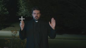 Priest with a cross outside
