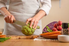 Primer, cocinero que prepara la alcachofa El concepto de comida sana y sana que pierde, detox, vegano que come, dieta, cocinando fotografía de archivo libre de regalías Primer, cocinero que prepara la alcachofa El concepto de comida sana y sana que pierde, detox, vegano que come, dieta, cocinando fotografía de archivo libre de regalías