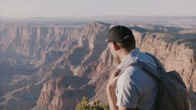Primer de la cámara lenta del hombre turístico joven feliz con la mochila emocionada por el panorama increíble del verano Grand C almacen de metraje de vídeo Primer de la cámara lenta del hombre turístico joven feliz con la mochila emocionada por el panorama increíble del verano Grand C almacen de metraje de vídeo
