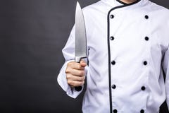 Primer de un cocinero que sostiene un cuchillo afilado grande imagen de archivo Primer de un cocinero que sostiene un cuchillo afilado grande imagen de archivo