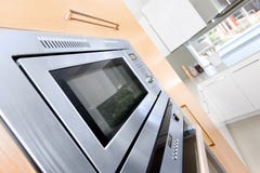 Primer de un horno moderno en una cocina de lujo fijada al de madera fotos de archivo Primer de un horno moderno en una cocina de lujo fijada al de madera fotos de archivo