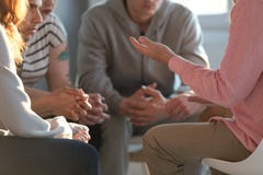 Primer de un terapeuta que gesticula mientras que habla con un grupo o foto de archivo Primer de un terapeuta que gesticula mientras que habla con un grupo o foto de archivo