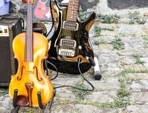 Primer de un violín y de una guitarra eléctrica laqueada negra en un mercado de pulgas fotografía de archivo Primer de un violín y de una guitarra eléctrica laqueada negra en un mercado de pulgas fotografía de archivo