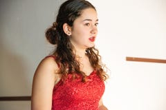 Primer del adolescente joven con el vestido rojo con las lentejuelas sin mangas fotografía de archivo Primer del adolescente joven con el vestido rojo con las lentejuelas sin mangas fotografía de archivo
