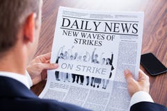 Primo piano del giornale di Reading News On dell'uomo d'affari fotografie stock Primo piano del giornale di Reading News On dell'uomo d'affari fotografie stock