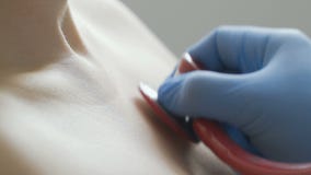 Primo piano di medico che esamina un paziente con uno stetoscopio video d archivio Primo piano di medico che esamina un paziente con uno stetoscopio video d archivio