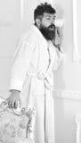 Privacy and secret concept. Man with beard and mustache eavesdrops using cup near wall. Hipster in bathrobe on surprised royalty free stock photography Privacy and secret concept. Man with beard and mustache eavesdrops using cup near wall. Hipster in bathrobe on surprised royalty free stock photography
