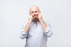 Problems with skin and wrinkles. Handsome caucasian man in white shirt stretching his skin on face. royalty free stock photography Problems with skin and wrinkles. Handsome caucasian man in white shirt stretching his skin on face. royalty free stock photography
