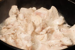 The process of cooking chicken breast diet for an athlete in a frying pan in sunflower oil. Meat for muscle recovery after royalty free stock image The process of cooking chicken breast diet for an athlete in a frying pan in sunflower oil. Meat for muscle recovery after royalty free stock image