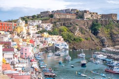 Procida, Italie Vue panoramique de Marina Corricella avec les maisons colorées en pastel, et Terra Murata en haut de la falaise images libres de droits Procida, Italie Vue panoramique de Marina Corricella avec les maisons colorées en pastel, et Terra Murata en haut de la falaise images libres de droits