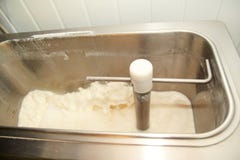 Procédé de fabrication de crème glacée à l'usine, au lait et à faire cuire de crème glacée le lait de mélange dans la machine de images libres de droits Procédé de fabrication de crème glacée à l'usine, au lait et à faire cuire de crème glacée le lait de mélange dans la machine de images libres de droits