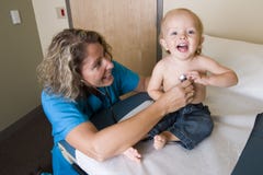Profesional médico femenino que controla el corazón de los childs Foto de archivo libre de regalías Profesional médico femenino que controla el corazón de los childs Foto de archivo libre de regalías