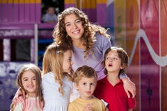 Professeur heureux With Cute Children dans l'école maternelle photo stock Professeur heureux With Cute Children dans l'école maternelle photo stock