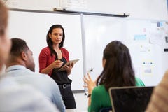 Professeur écoutant des étudiants à une classe d'éducation des adultes image libre de droits Professeur écoutant des étudiants à une classe d'éducation des adultes image libre de droits