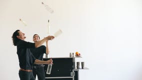 Professinal玩杂耍瓶和震动鸡尾酒的侍酒者人在白色背景演播室的流动酒吧桌上户内 库存照片 Professinal玩杂耍瓶和震动鸡尾酒的侍酒者人在白色背景演播室的流动酒吧桌上户内 库存照片