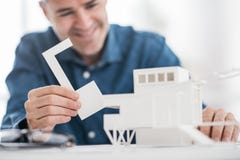 Professional architect working at office desk, he is assembling an architectural model, design and architecture concept stock images Professional architect working at office desk, he is assembling an architectural model, design and architecture concept stock images