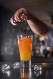 Professional bartender prepares and mixes cocktails pouring red syrup from a bottle on the background of a bar royalty free stock photography Professional bartender prepares and mixes cocktails pouring red syrup from a bottle on the background of a bar royalty free stock photography
