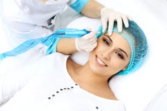 Professional beautician doing eyebrow tattoo at woman face. Permanent brow makeup in beauty salon, closeup. Cosmetolog stock photo Professional beautician doing eyebrow tattoo at woman face. Permanent brow makeup in beauty salon, closeup. Cosmetolog stock photo