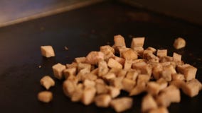A chef is cooking food in restaurant, cooking chiken in the cooktop stock footage A chef is cooking food in restaurant, cooking chiken in the cooktop stock footage