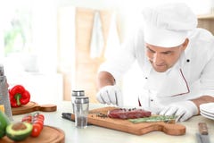 Professional chef cooking meat on table Royalty Free Stock Image Professional chef cooking meat on table Royalty Free Stock Image