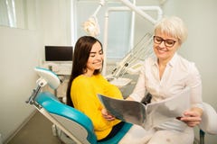 Professional doctor shows to the patient picture of healthy teeth in his medical dental office. Secret of healthy teeth royalty free stock photo Professional doctor shows to the patient picture of healthy teeth in his medical dental office. Secret of healthy teeth royalty free stock photo