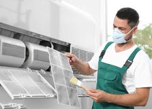 Professional Male Technician Cleaning Air Conditioner. Repair And Maintenance Royalty Free Stock Image