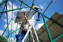Professional mounters team installing solar batteries on metallic carcass. royalty free stock images Professional mounters team installing solar batteries on metallic carcass. royalty free stock images