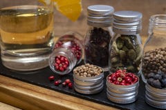 Professional set of gin spices in small bottles, pink pepper, hibiscus flowers, juniper berries, cardamom and coriander seeds