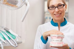 Professionele tandarts die bij zijn tandkliniek werken stock afbeelding Professionele tandarts die bij zijn tandkliniek werken stock afbeelding