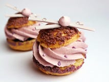 Profiteroles слойки сливк лаванды с меренгами и белым шоколадом стоковая фотография Profiteroles слойки сливк лаванды с меренгами и белым шоколадом стоковая фотография