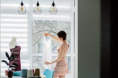 Progettista femminile che lavora con il vestito tricottato nello studio accogliente interno, indipendente, stile di vita, concett immagini stock Progettista femminile che lavora con il vestito tricottato nello studio accogliente interno, indipendente, stile di vita, concett immagini stock